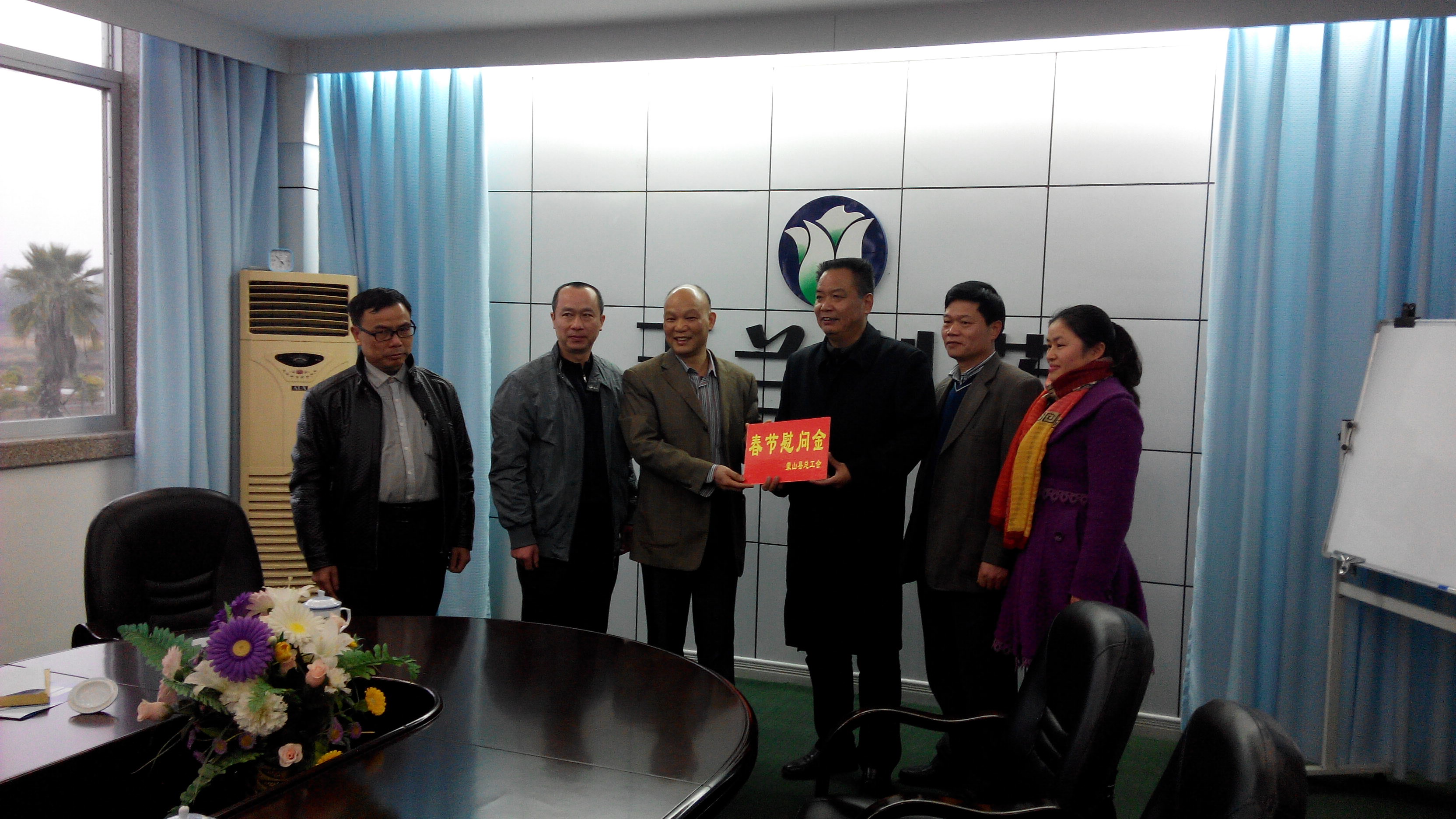 1月28日，梧州市總工會副主席謝海益帶隊到蒙山開展春節(jié)前慰問活動。圖為市總工會謝副主席給玉蘭制藥公司送上春節(jié)慰問金。--