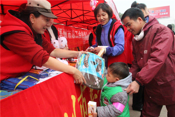 市總工會(huì)黨員義工為返鄉(xiāng)務(wù)工的小孩送上書(shū)包