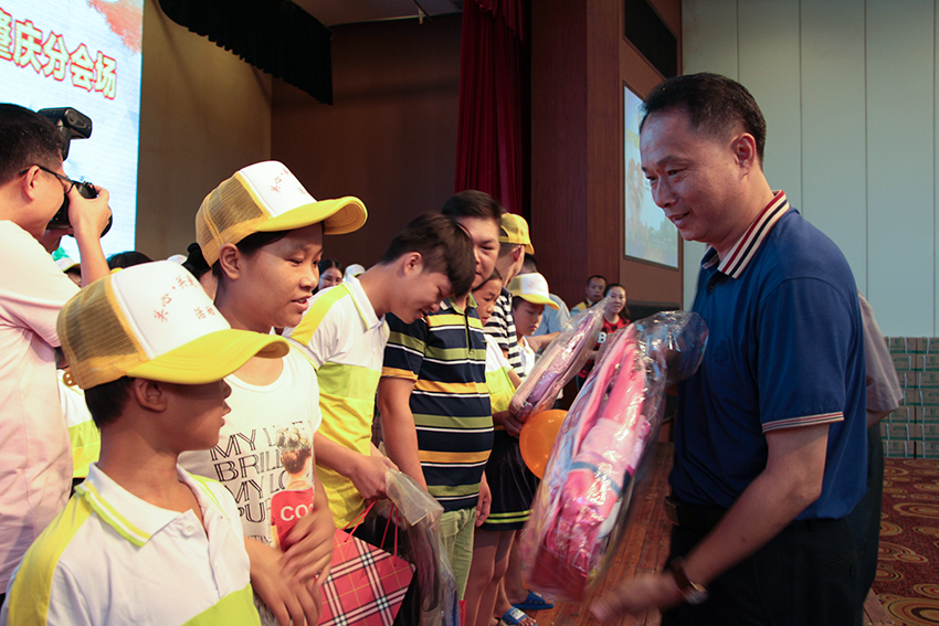 9.梧州市總工會黨組書記、常務副主席梁耀忠為農民工子女贈送書包、文具.jpg